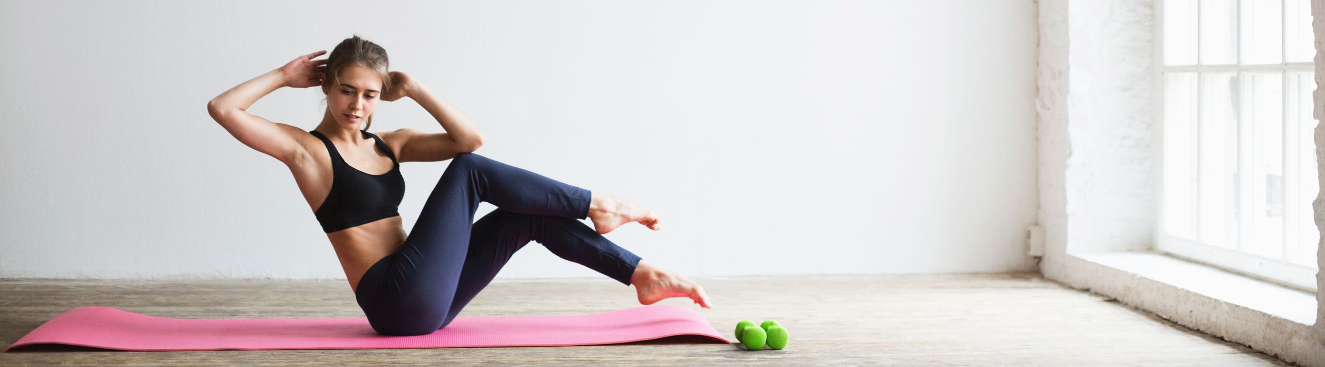 Sportieve vrouw doet butterfly sit-ups op een yogamat